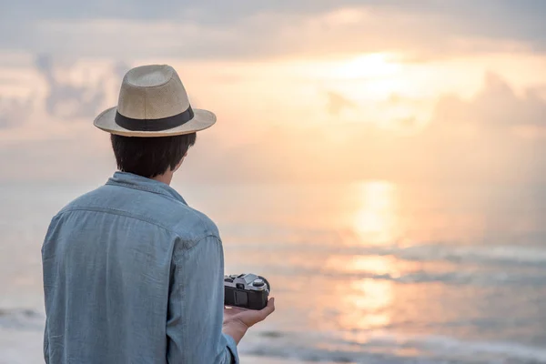 Młody człowiek Asian traveler patrząc na zachód słońca na tropikalnej plaży — Zdjęcie stockowe