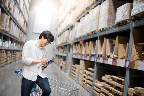 Joven asiático hombre comprobar la lista de la compra en almacén —  Fotos de Stock