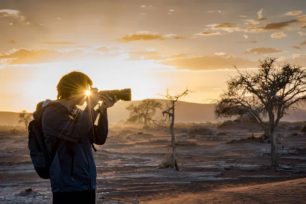Sunstars efekt očima mužů fotograf v ranní sunris — Stock fotografie
