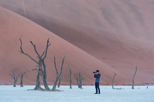 Un tânăr fotograf a fotografiat un copac mort în deadvlei — Fotografie, imagine de stoc