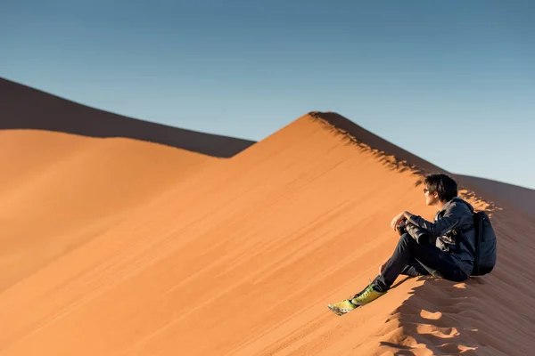 Tineri fotografi de sex masculin care stau pe duna de nisip, Namibia — Fotografie, imagine de stoc