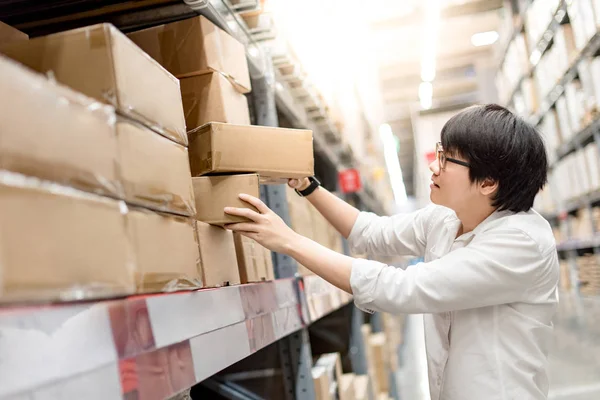 Joven asiático hombre recogiendo cajas de papel en almacén —  Fotos de Stock