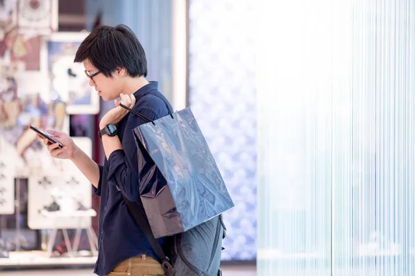 Tineri asiatici care dețin geanta de cumpărături albastră în magazin — Fotografie, imagine de stoc