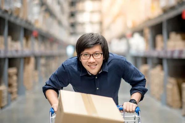 Jovem asiático homem compras com carrinho de carrinho no armazém — Fotografia de Stock