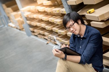 Depoda tablet kullanarak stocktaking yapan genç Asyalı erkek