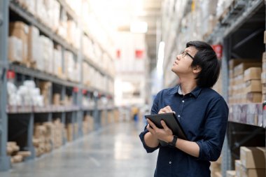 Depoda tablet kullanarak stocktaking yapan genç Asyalı erkek