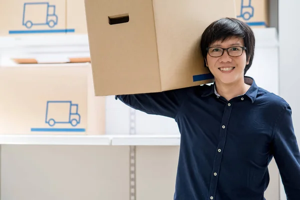 Jovem asiático feliz homem carregando caixa de papelão — Fotografia de Stock