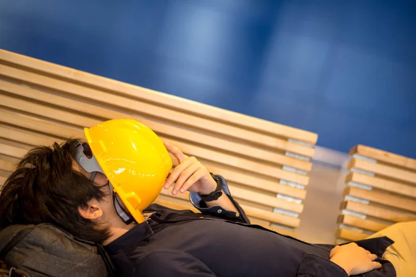 Junger asiatischer Ingenieur liegt auf Bank — Stockfoto