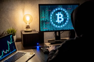 Bitcoin yeşil ikili grafik ve cryptocurrency şamdan grafiği fiyat ile monitör ekranında dizüstü bilgisayar ve bilgisayar kullanan hacker adam. Siber suç dijital para aklama kavramı