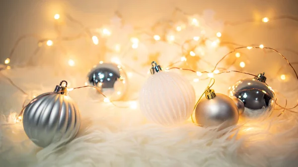お祝いのライトと毛むくじゃらのカーペット上のクリスマスボール — ストック写真