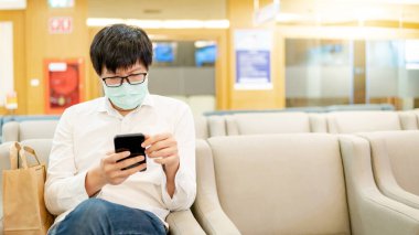 Hastanede akıllı telefon kullanan bir erkek hasta.
