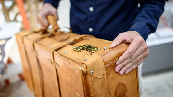 Mão masculina carregando mala de couro antigo — Fotografia de Stock