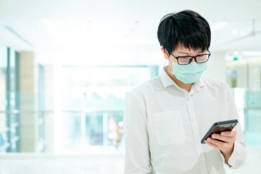 Male patient using smartphone in hospital