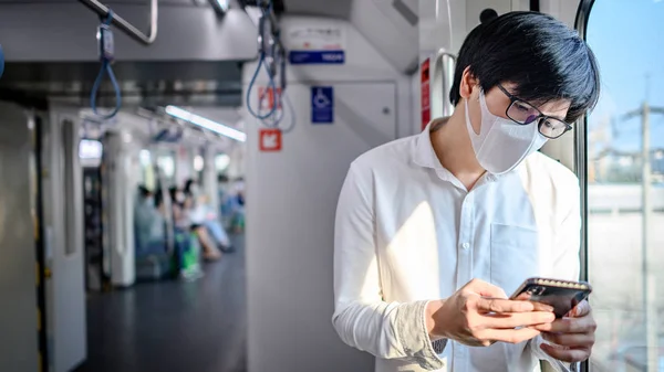 Aziatische Man Draagt Chirurgische Gezichtsmasker Met Behulp Van Smartphone Skytrain — Stockfoto