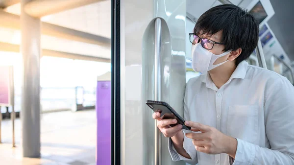 Aziatische Man Draagt Chirurgische Gezichtsmasker Met Behulp Van Smartphone Stedelijke — Stockfoto