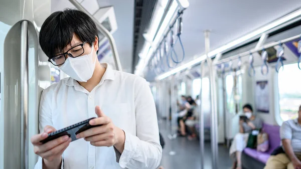 Aziatische Man Draagt Chirurgische Gezichtsmasker Met Behulp Van Smartphone Skytrain — Stockfoto