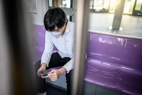 Hombre Asiático Con Mascarilla Quirúrgica Usando Smartphone Skytrain Tren Urbano —  Fotos de Stock