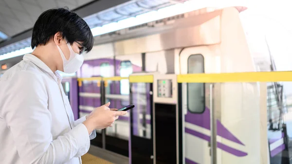 Pria Asia Memakai Masker Operasi Wajah Menggunakan Smartphone Stasiun Skytrain — Stok Foto