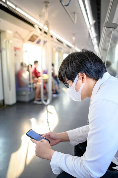 Aziatische Man Draagt Chirurgische Gezichtsmasker Met Behulp Van Smartphone Skytrain — Stockfoto