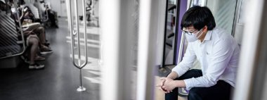 Hava treninde ya da şehir treninde oturan cerrahi maske takan Asyalı bir adam. Wuhan Coronavirus (COVID-19) toplu taşımacılıkta salgın önleme. Pandemik koruma için sağlık farkındalığı