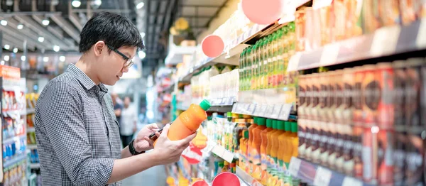 Asian Man Choosing Orange Juice Supermarket Using Smartphone Check Shopping — Stock Photo, Image