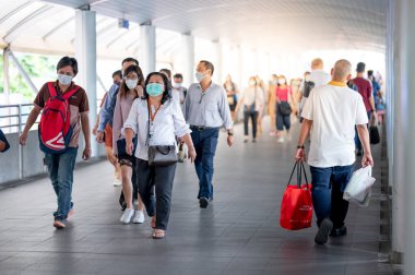 THAILAND, BANGKOK - 16 Mart 2020: Coronavirus (COVID-19) salgınını ve PM2.5 hava kirliliğini korumak için maske takan kalabalık kalabalık kalabalık yoğun saatlerde kent yolunda yürüyor.