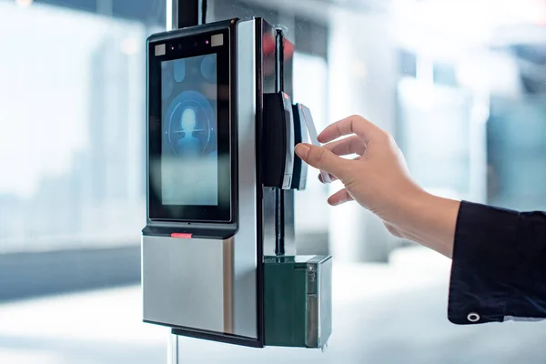Ofis binasının camlı kapısının güvenlik kilidini açmak için anahtar kartı kullanan bir erkek. Gizlilik ve güvenlik için biyometrik kimlik doğrulama aygıtı.