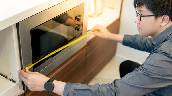 Hombre Asiático Diseñador Interiores Utilizando Cinta Métrica Horno Microondas Sala —  Fotos de Stock