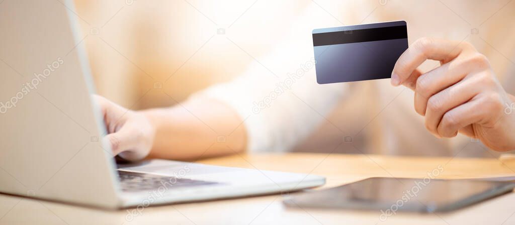 Male customer hand using credit card for online shopping during quarantine at home. Male shopper buying goods and making payment with electronic banking. Financial technology concept