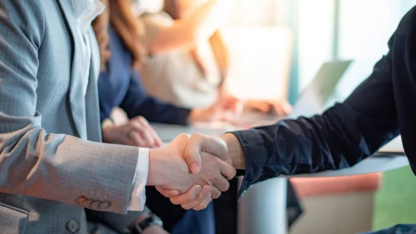 Business agreement and collaborative partnership concept. Business people shaking hands at meeting.  Asian businessman partner handshake.
