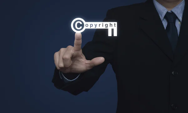 Businessman pressing copyright key icon on blue background, Copy — Stock Photo, Image