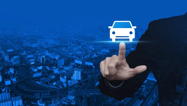 Affärsman som att trycka på bilen framifrån flat ikonen över city tower — Stockfoto