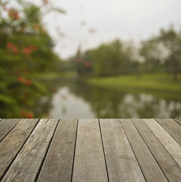 Lege oude houten vloer met wazig rode bloem en boom — Stockfoto