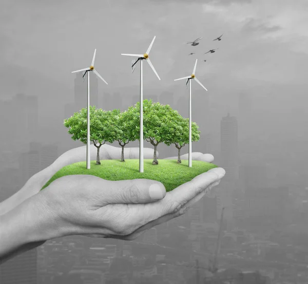 Wind turbines, grass and trees in human hands over pollution city, Ecological concept — Stock Photo, Image