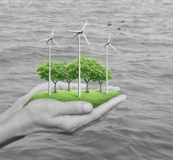 Turbinas eólicas, grama e árvores em mãos humanas — Fotografia de Stock