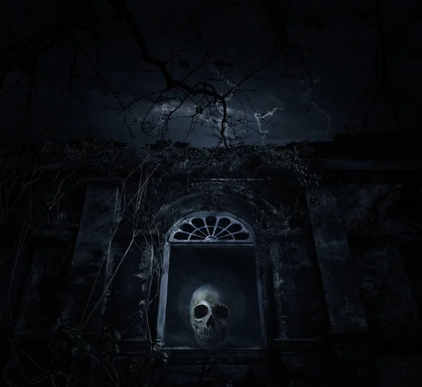 Crânio humano no antigo castelo da janela com árvore morta sobre a lua — Fotografia de Stock