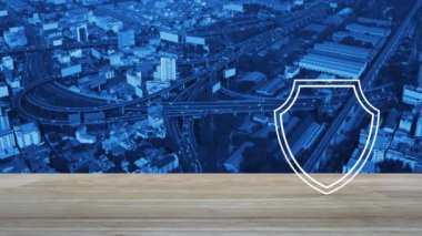 Güvenlik kalkanı ahşap masa üzerinde tahta simge ile modern şehir kulesi, sokak, ekspres yol ve gökdelen, teknoloji internet siber güvenlik ve anti virüs konsepti üzerinde