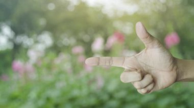 Parkta bulanıklık pembe çiçek ve ağaç üzerinde parmak kalkan düz simgesi ile Motosiklet, İş motosiklet sigorta konsepti