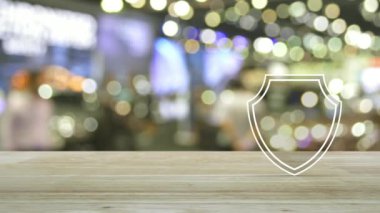 Alış veriş merkezinin gölgesi ve iş güvenliği konsepti üzerine ahşap masanın üzerinde simgesi olan asma kilit.