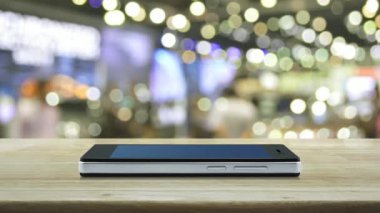 bulanıklık ışık ve alışveriş merkezinin gölgesi üzerinde ahşap masada modern akıllı cep telefonu ekranında e-posta düz simgesi, İş iletişimi online kavram