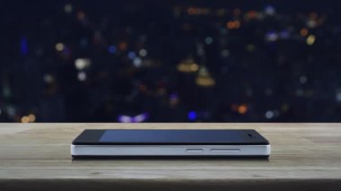 Soru işareti simgesi simgesi modern akıllı cep telefonu ekranında ahşap masa üzerinde bulanık gece lambası şehir kulesi ve gökdelen, iş dünyası müşteri hizmetleri ve çevrimiçi konsept desteği üzerinde