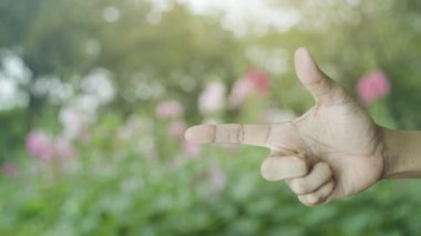 Parktaki bulanık pembe çiçek ve ağaç üzerinde parktaki simgeyle el sıkışan asma kilit, iş güvenliği sigortası kavramı