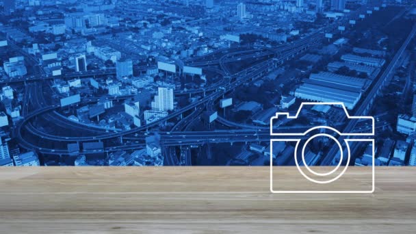 现代城市塔 高速公路和摩天大楼空中俯瞰木制桌子上的相机平面图标 商业相机服务商店概念 — 图库视频影像