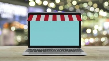 Çevrimiçi alışveriş mağazası grafikli ve açık tabelalı modern dizüstü bilgisayar, bulanık ışık ve alışveriş merkezinin gölgesi, İnternet üzerinden iş yeri internet mağazası konsepti