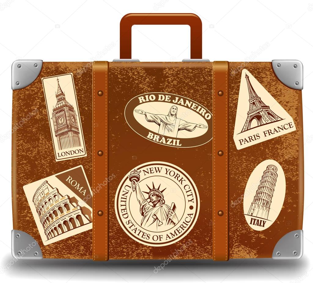 Vintage brown threadbare suitcase with retro stickers famous places