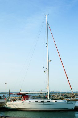 Beyaz mavi deniz ve gökyüzü karşı wharf yakınındaki yat