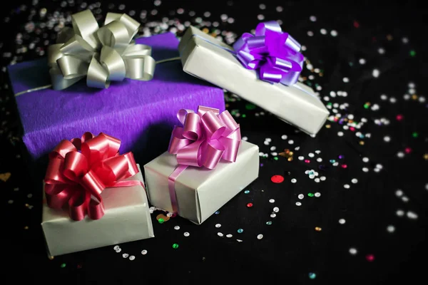 Caixas de presente quadradas em um fundo festivo preto com brilhos — Fotografia de Stock