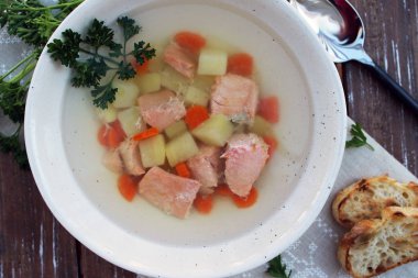 Patatesli somon çorbası ve ahşap zemin üzerinde havuç.