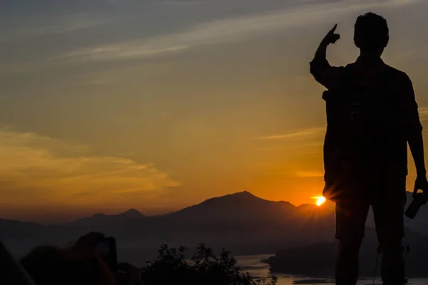 Yong man die op de achtergrond van de zonsondergang — Stockfoto