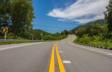Mavi gökyüzü olan boş bir köy yolu. 